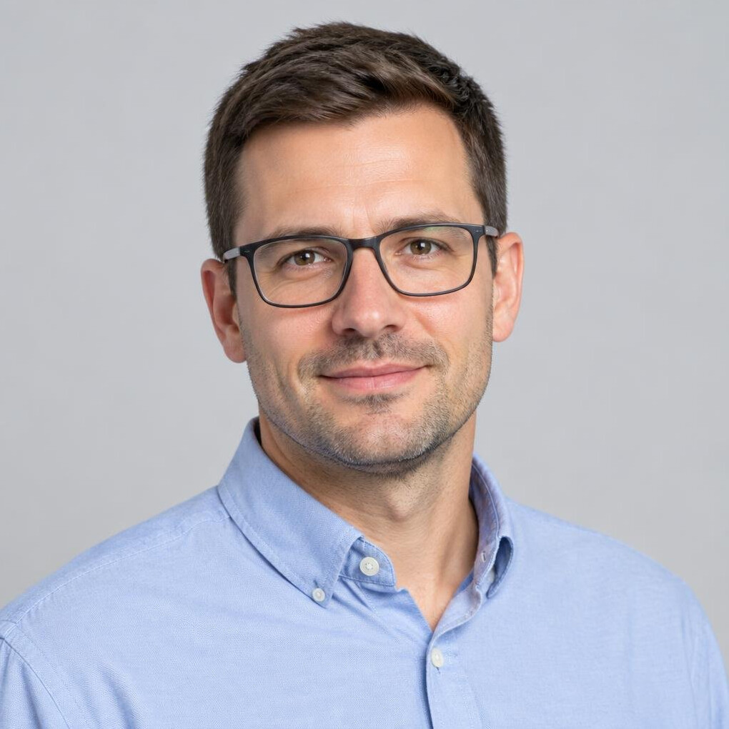 Studio portrait of a Croatian man in his thirties with short hair and glasses